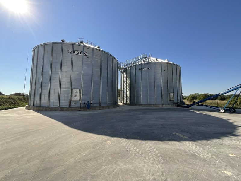Steel silos for longer-term storage of dried grain, on a concrete apron.