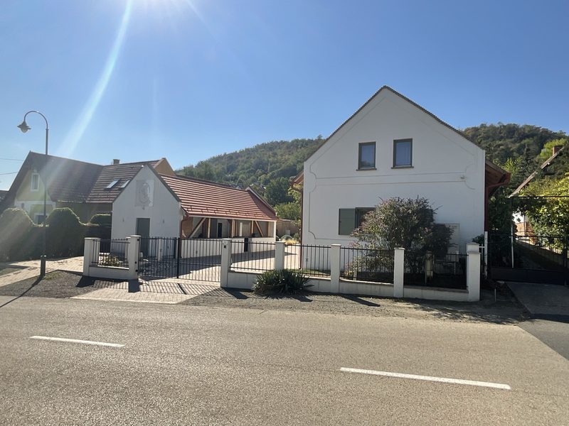 The guest building and the outbuilding on the street line, with the Szigliget hillside behind.
