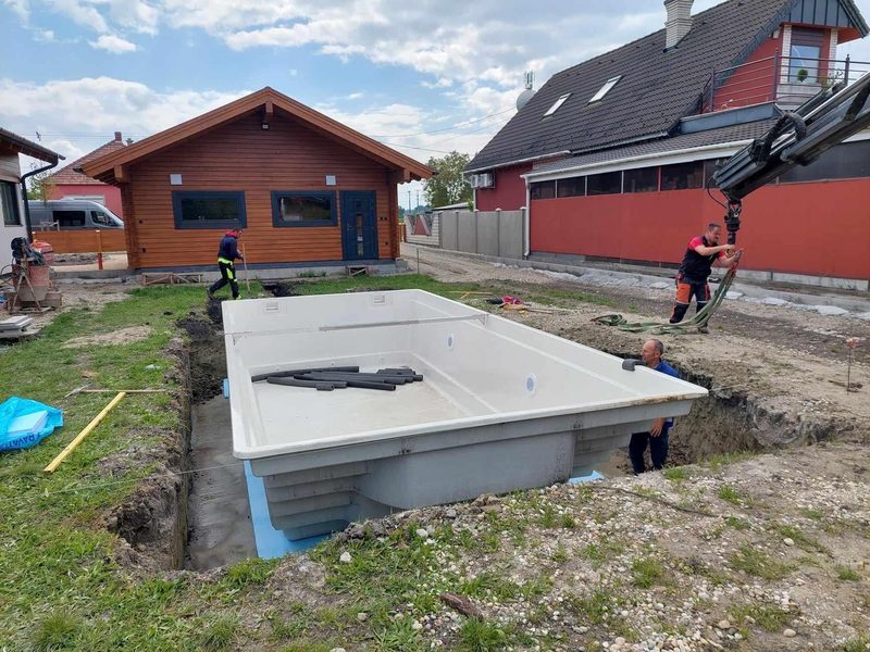Einheben des vorgefertigten Poolbeckens, dahinter das Nebengebäude.