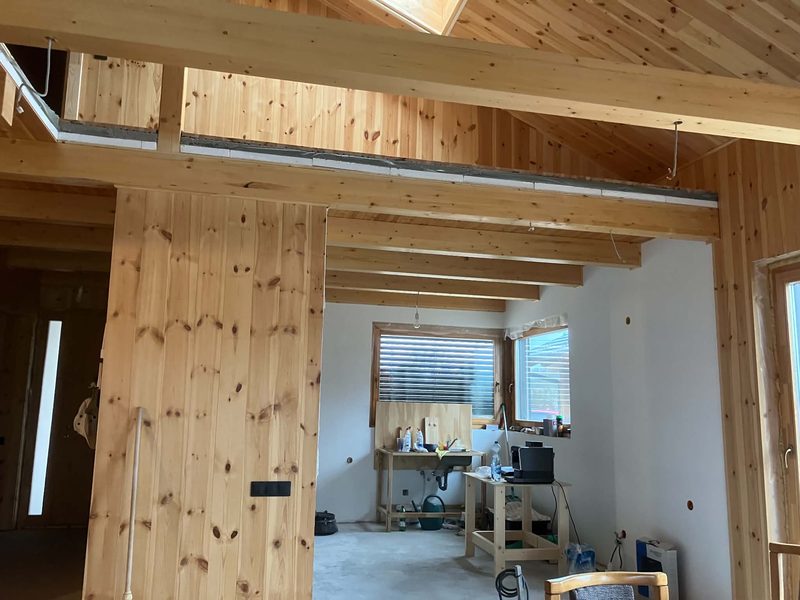 Holzverkleidete Innenwände und sichtbare Balken während des Innenausbaus.
