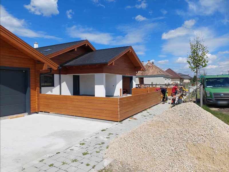 Garage und überdachter Eingang mit gepflasterter Zufahrt während der Montage des Holzzauns.