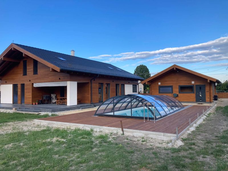 Das fertige holzverkleidete Haus, mit Teleskopüberdachung über dem Pool.
